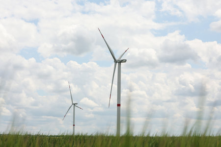 Modern wind turbines in field on cloudy day. alternative energy sources