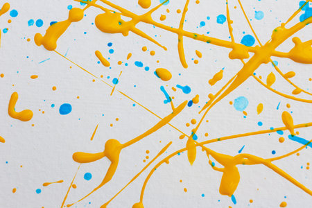 Colorful paint splashes on white canvas as background. Art and creativity
