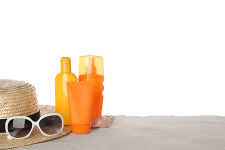 Composition with sun protection products on sand against white background. Space for text
