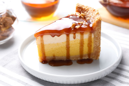 Slice of delicious cake with caramel sauce on tableの写真素材