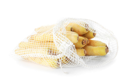 Raw carrots in mesh bag isolated on whiteの写真素材