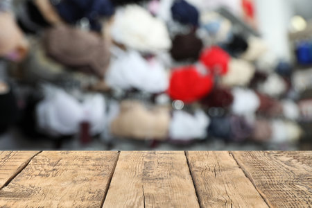 Empty wooden table and blurred view of different underwear. Clothes shopの写真素材