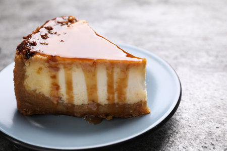 Piece of delicious cake with caramel served on gray table, closeupの写真素材