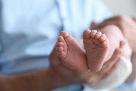 Father holding his newborn baby at home, closeup. Space for textの写真素材