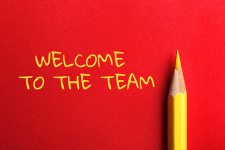 Phrase Welcome to the team and pencil on red background, top viewの写真素材