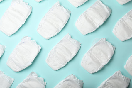 Flat lay composition with baby diapers on light blue background