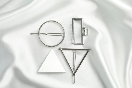 Beautiful different hair clips on white fabric, flat lay