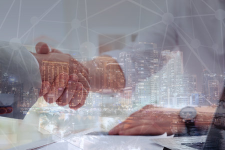Double exposure of partners shaking hands and night city. business values