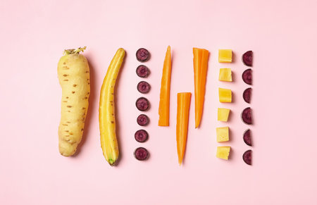Whole and cut raw color carrots on pink background, flat layの写真素材