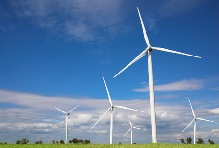 alternative energy sources. Wind turbines in field under blue sky