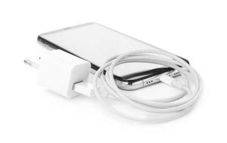 Smartphone and USB charger on white background. modern technology