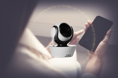 CCTV camera and woman with smartphone indoors, closeup