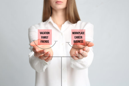 Work-life balance concept. Woman demonstrating illustration of scales with words on light background, closeupの写真素材