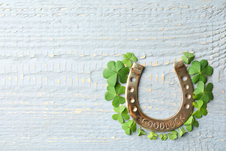 Clover leaves and horseshoe on wooden table, flat lay with space for text. St. Patrick's Day celebrationの写真素材