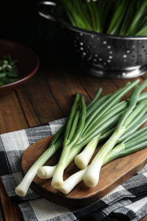 Fresh green spring onions on wooden boardの写真素材