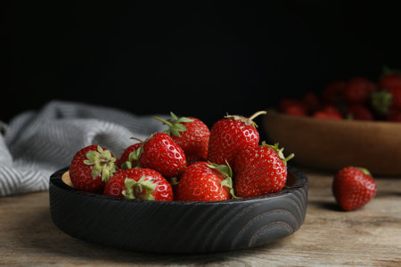 Delicious ripe strawberries on wooden plate, closeupの写真素材