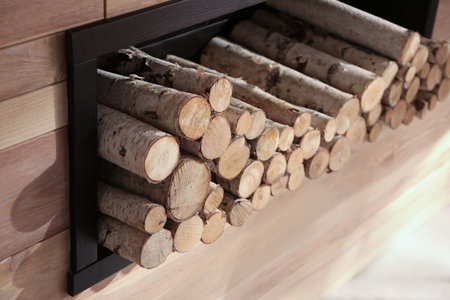 Decorative fireplace with stacked wood indoors. Idea for interior design