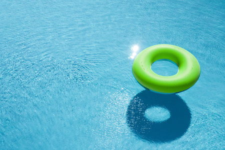 Inflatable ring floating in swimming pool, space for text. summer holidays