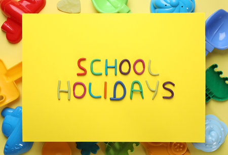 Flat lay composition with phrase School Holidays made of modeling clay on yellow backgroundの写真素材