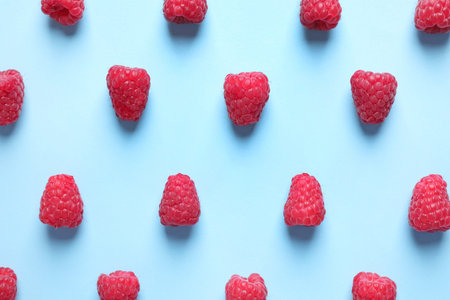 Fresh sweet ripe raspberries on light blue background, flat layの写真素材