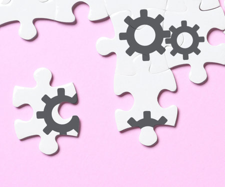 teamwork concept. White puzzle pieces on pink background, flat lay