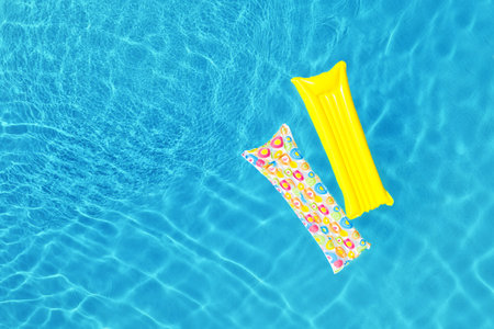 Swimming pool with inflatable mattresses, top view. Space for text