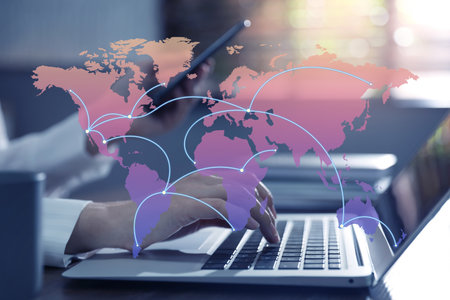 Wholesale and logistics concept. Woman using laptop in office, world map illustration on foreground