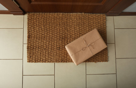 Parcel on rug near door, flat lay. delivery serviceの写真素材