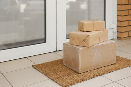 Delivered parcels on door mat near entranceの写真素材