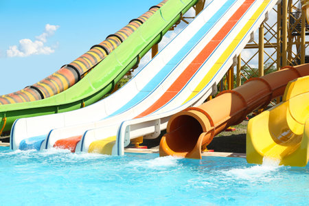 Different colorful slides in water park on sunny day