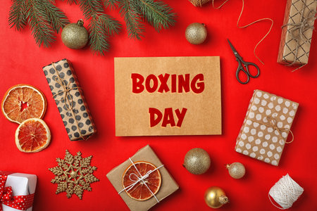 Flat lay composition with gifts and text Boxing Day on red backgroundの写真素材