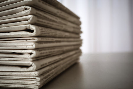 Stack of newspapers on gray table, space for design. Journalist's workの写真素材