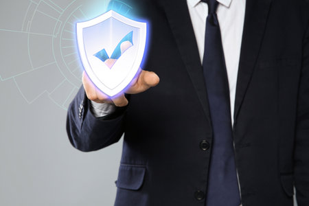 Cyber insurance concept. Man using virtual screen with shield illustration as symbol of protection,...