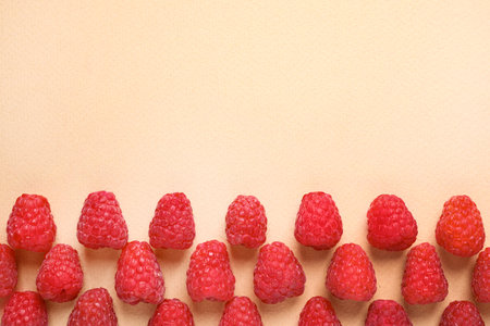 Fresh sweet ripe raspberries on beige background, flat lay. Space for text