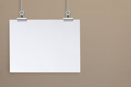 Blank poster hanging near beige wall. space for designの写真素材
