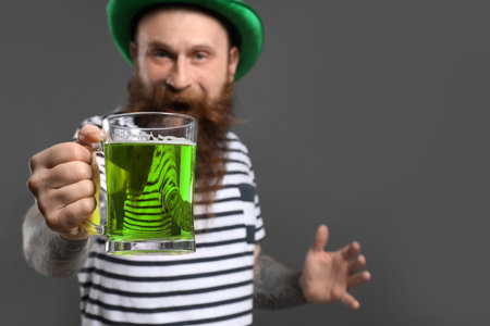 Bearded man with green beer on gray background. St. Patrick's Day celebrationの写真素材