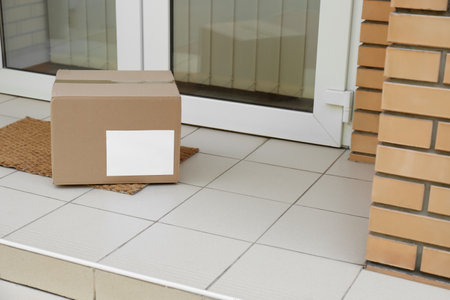 Delivered parcel on door mat near entranceの写真素材