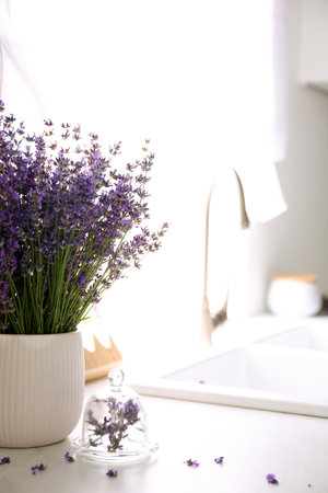 Beautiful lavender flowers on countertop in kitchen. Space for textの写真素材