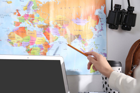 Woman with world map planning trip at home, closeup. summer holidays