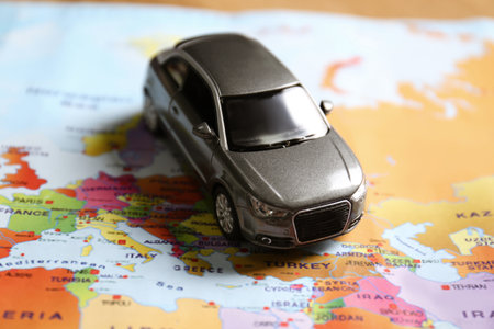 Gray toy car on world map. trip planning