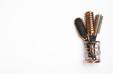 Modern hair brushes in holder on white background, top viewの写真素材