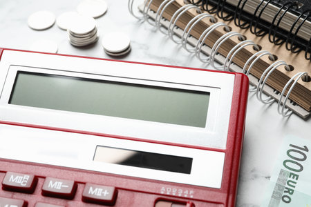 Calculator, money and notebooks on marble table, closeup. tax accountingの写真素材