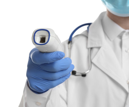 Doctor in latex gloves holding non contact infrared thermometer on white background, closeup....
