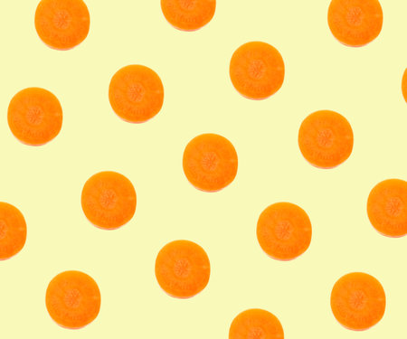 Pattern design with carrot slices on pale yellow backgroundの写真素材