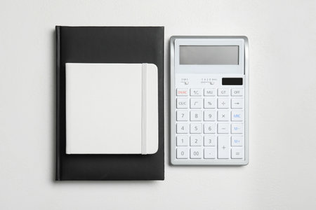 Calculator and notebooks on white background, flat lay. tax accountingの写真素材