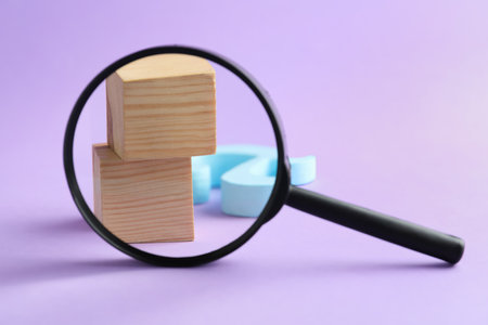 Magnifier glass, wooden cubes and letter A on purple background, closeup. Find keywords conceptの写真素材