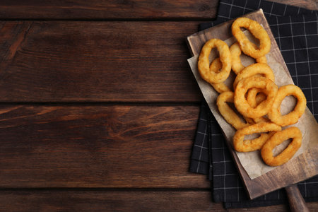 Fried onion rings served on wooden table, top view. Space for textの写真素材