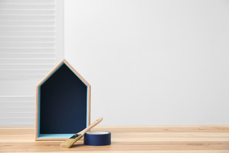 House shaped shelf and decorator tools on table indoors. Space for textの写真素材