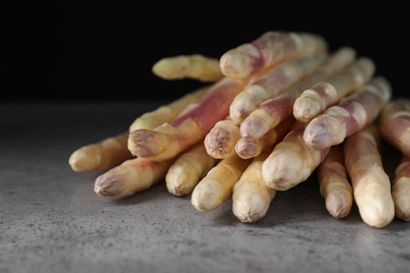 Pile of fresh white asparagus on gray table, closeupの写真素材