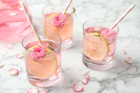 Refreshing drink with lemon and rose on white marble tableの写真素材